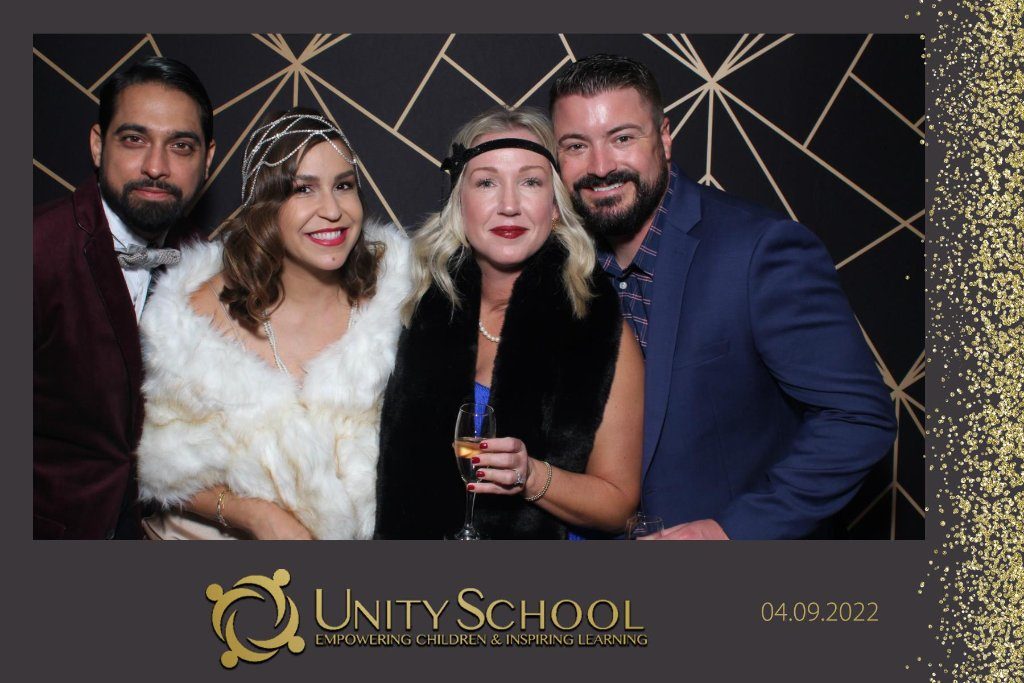 Guests in front of a gold art-deco backdrop at a school gala