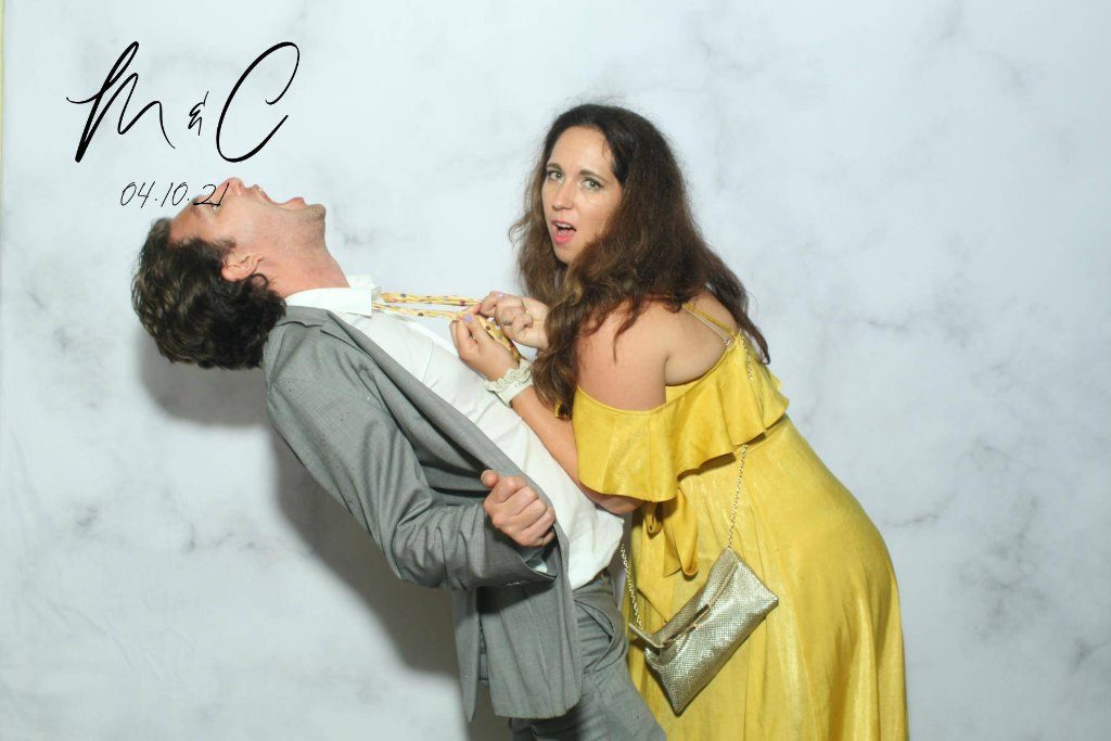 Couple striking a playful dip pose against a marble backdrop