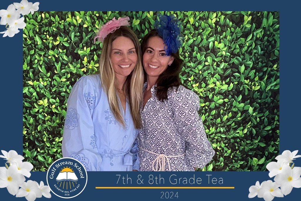 Two guests in front of a greenery wall at a school tea