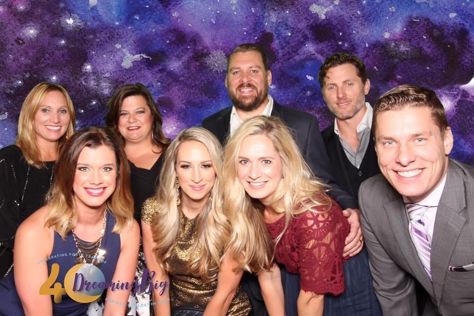 Group of guests in front of a galaxy backdrop at a birthday celebration