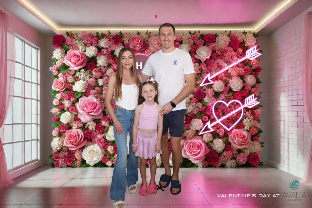 Family in front of a pink flower wall at a Valentine's event