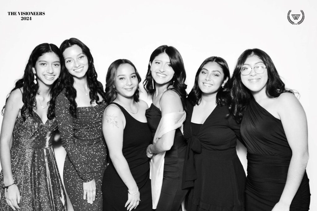 Five friends posing in a black and white glam booth photo